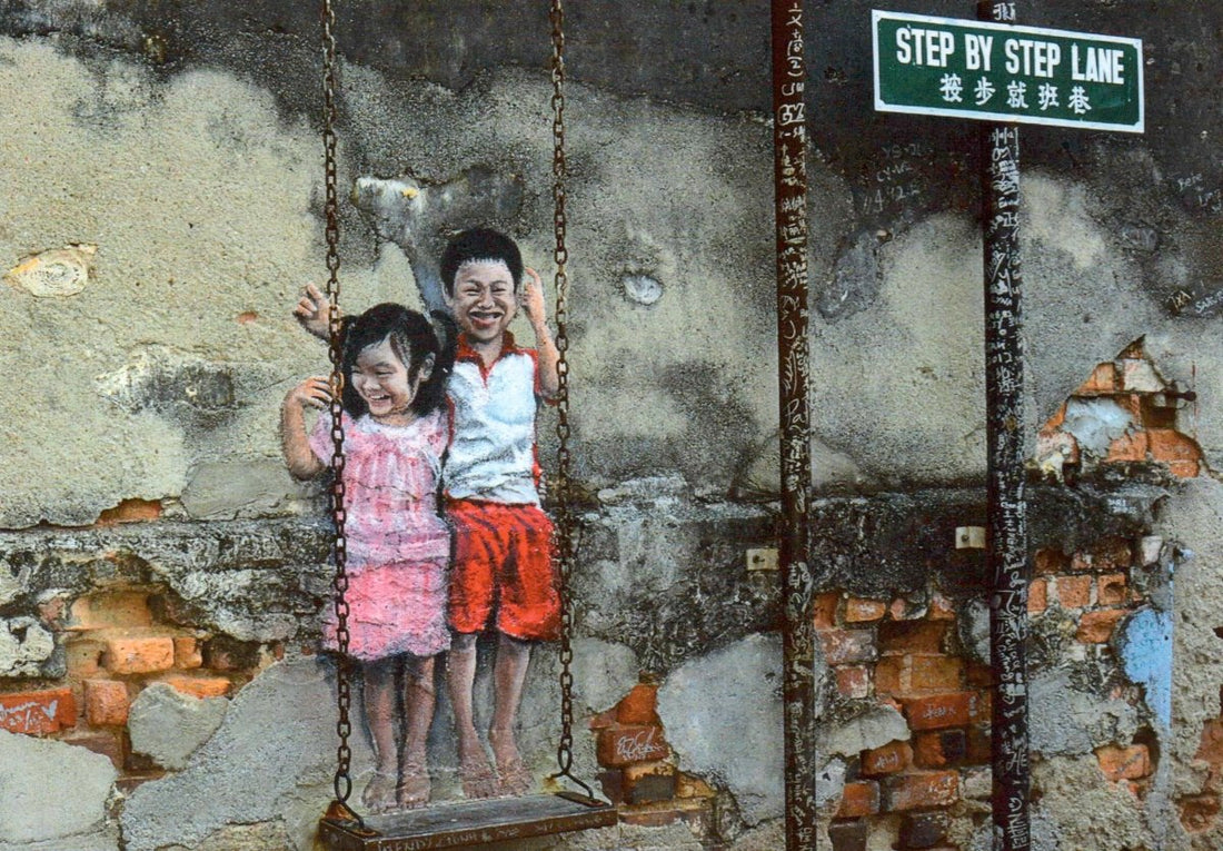 Geburtstags - Postkarte mit Street Art Motiv - Kinder auf Schaukel vor Mauerwerk - Urban Kunstpostkarte, Blanko, Step by Step Lane Graffiti, Realistisch Spielen & Freude, Geschwister Outdoor - Erlebnis