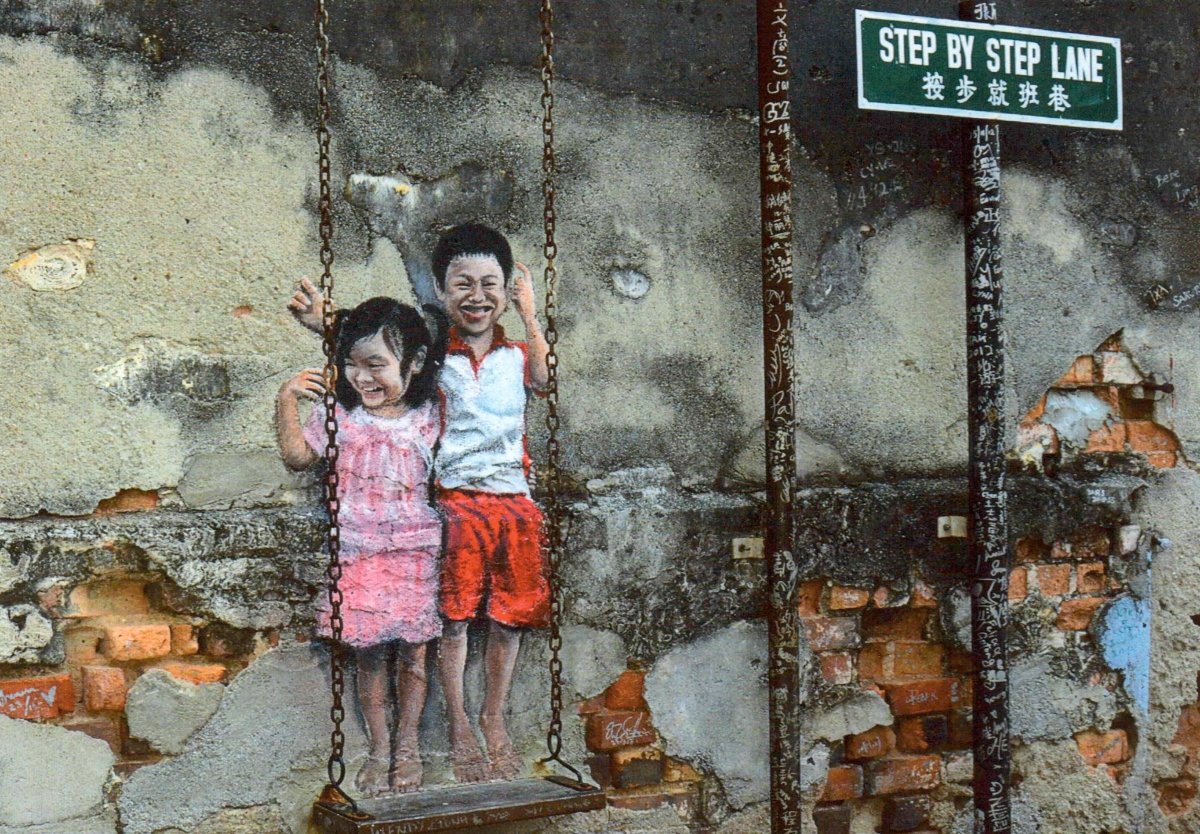 Geburtstags - Postkarte mit Street Art Motiv - Kinder auf Schaukel vor Mauerwerk - Urban Kunstpostkarte, Blanko, Step by Step Lane Graffiti, Realistisch Spielen & Freude, Geschwister Outdoor - Erlebnis