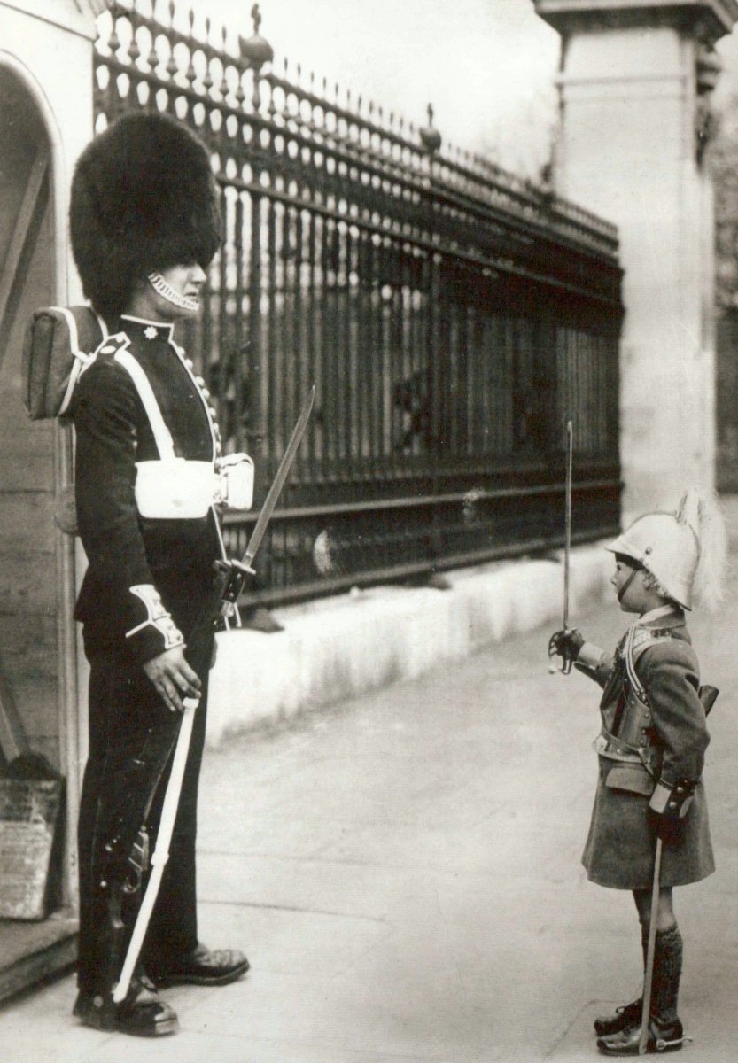 Geburtstagskarte im Retrostil - Humorvolle Schwarz - Weiß Fotografie mit Soldat, Kind in Uniform und Bärenfellmütze am Zaun